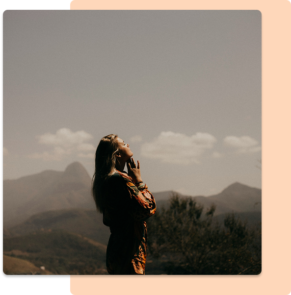 A woman thinking on the top of the mountain.